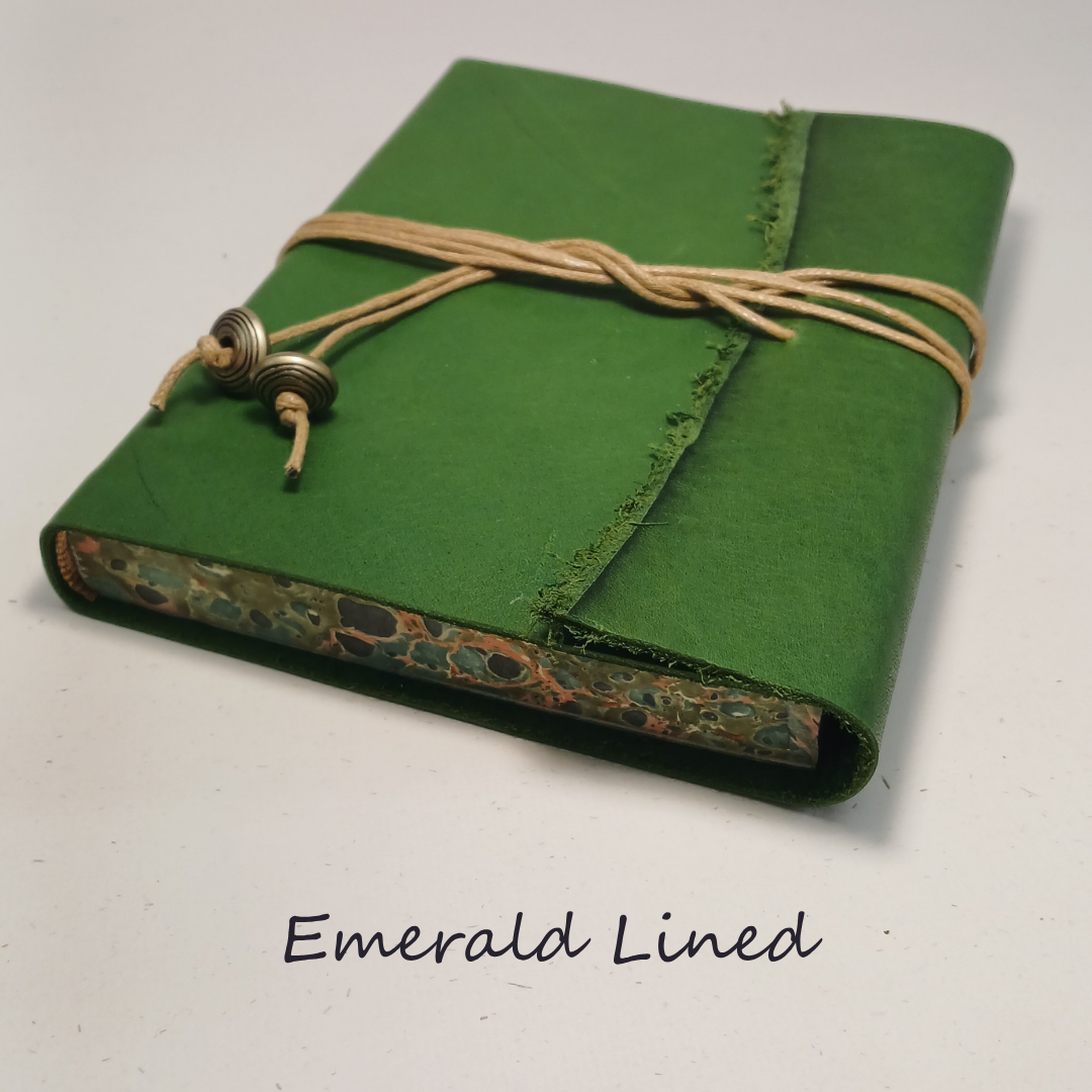 Green notebook with decorative binding on a white background