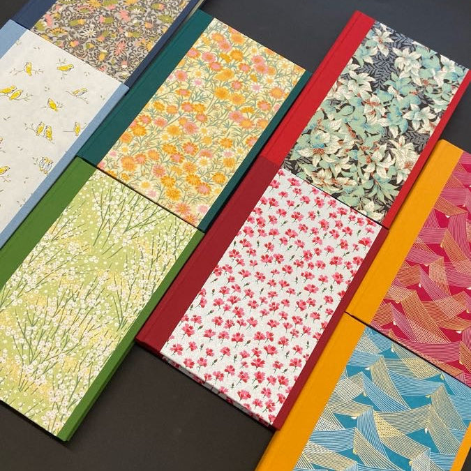 Collection of notebooks with various colorful patterns on a black background