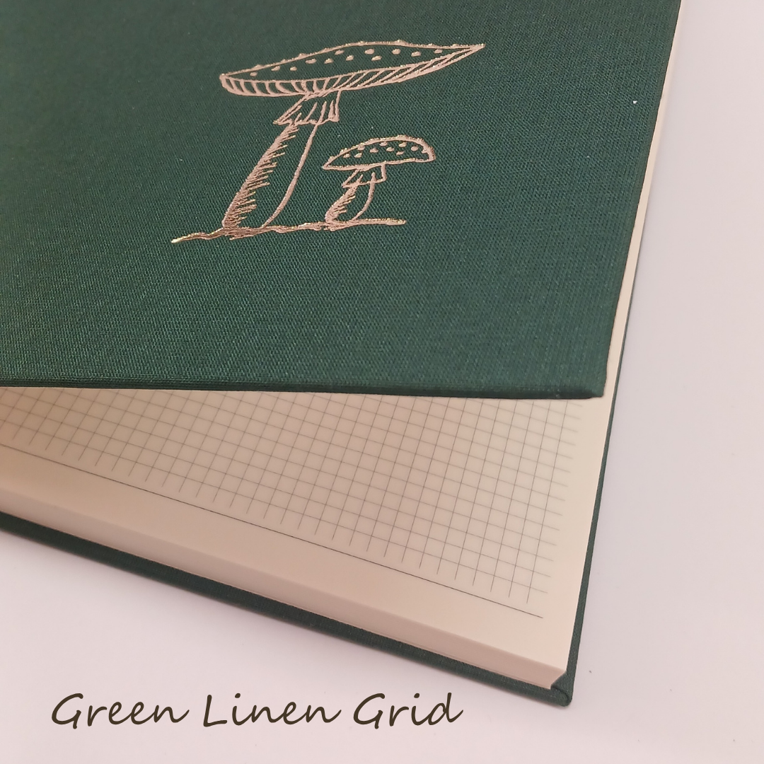 Green notebook with mushroom design and grid interior on a white background