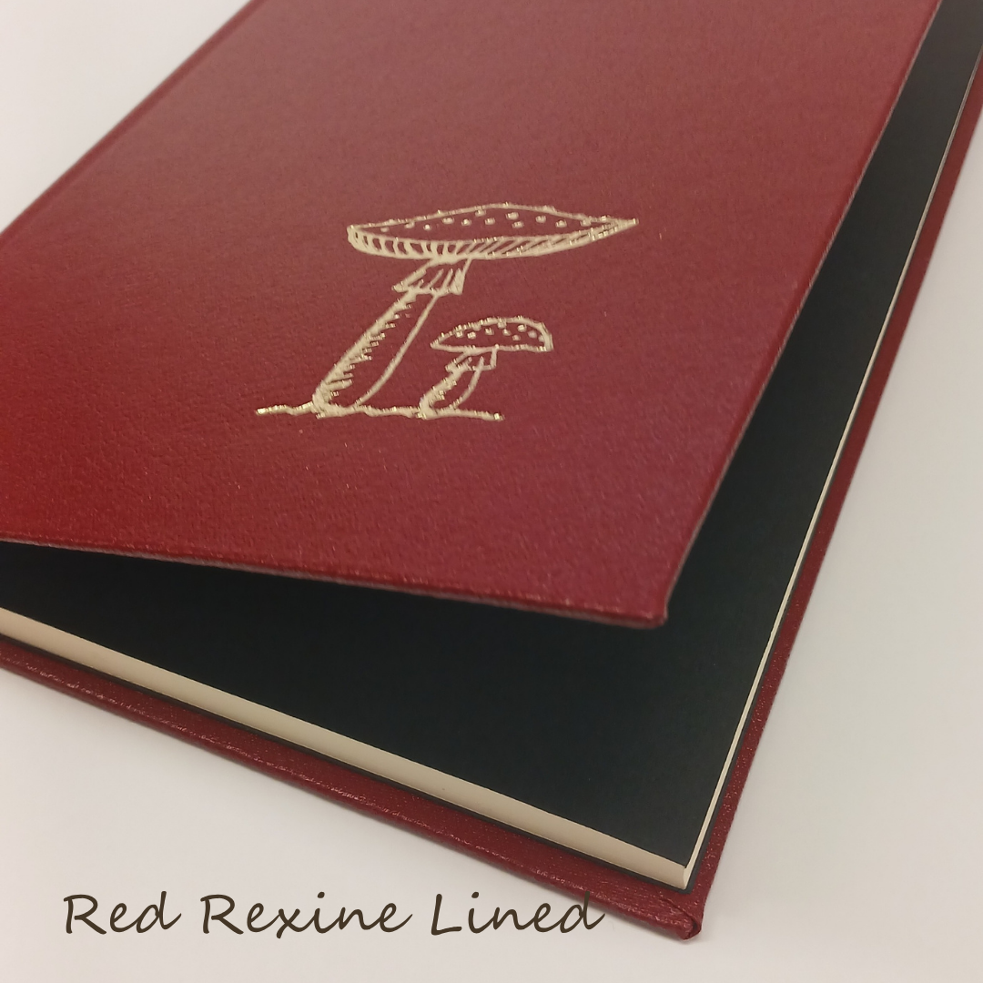 Red rexine lined notebook with mushroom design on a white background
